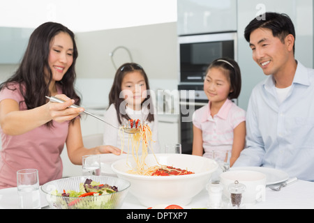 Glückliche Frau Spaghetti für die Familie in Küche Stockfoto