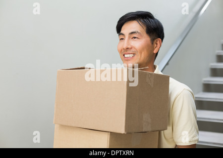 Lächelnde junge Mann trägt Boxen Stockfoto