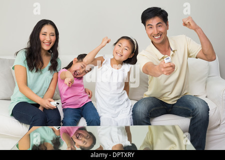 Glückliche Familie von vier vor dem Fernseher im Wohnzimmer Stockfoto