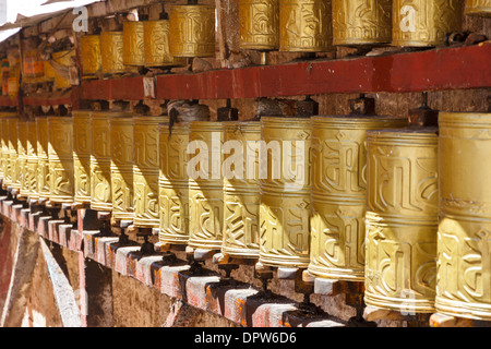 Gold farbige buddhistische Gebetsmühlen im Zentrum der Stadt Lhasa, Tibet Stockfoto