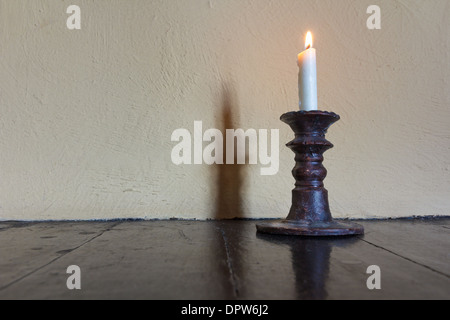 Brennende Kerze in alten Leuchter auf Holztisch Stockfoto