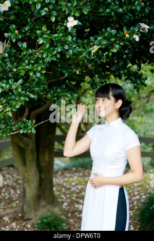 Junge Frau in Woodland Park Lächeln tragen traditionelle vietnamesische Kleidung. Stockfoto