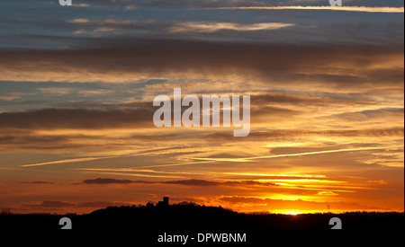 Die Sonne versinkt hinter der Kirche St Mary und St. Hardulph in Breedon auf dem Hügel, Leicestershire Stockfoto