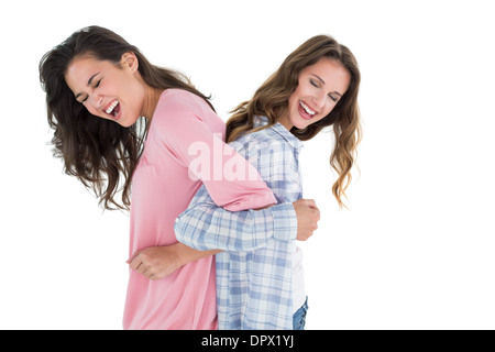 Frauen stehen Rücken an Rücken mit Interlock Händen Stockfoto