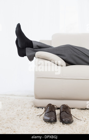 Geringen Teil der Geschäftsmann ruht auf Sofa im Wohnzimmer Stockfoto