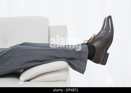 Niedrigen Bereich Seitenansicht eines Geschäftsmannes ruht auf sofa Stockfoto