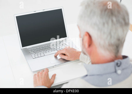 Close-up Rückansicht von einem grauen Haaren Mann mit Laptop am Schreibtisch Stockfoto