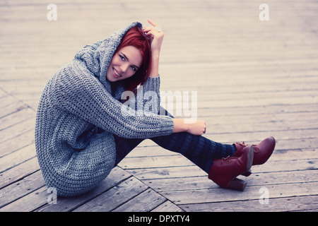 Junge schlanke Frau sitzen im Freien. Stockfoto