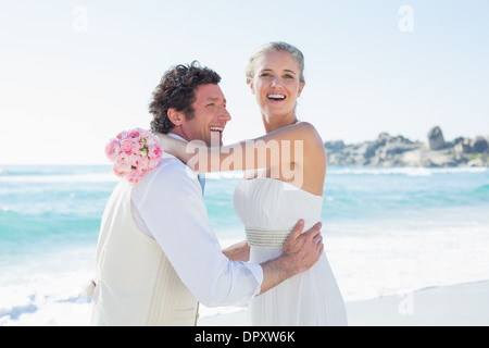 Lachend hob seine hübsche neue Frau Bräutigam Stockfoto