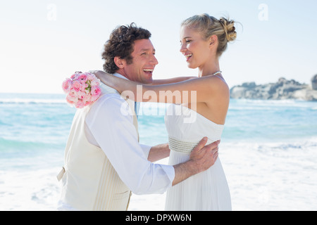 Lachend hob seine hübsche Frau Bräutigam Stockfoto