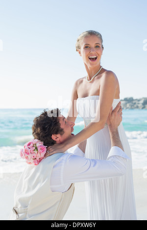 Bräutigam, hob seine hübsche blonde Frau lächelt in die Kamera lachen Stockfoto