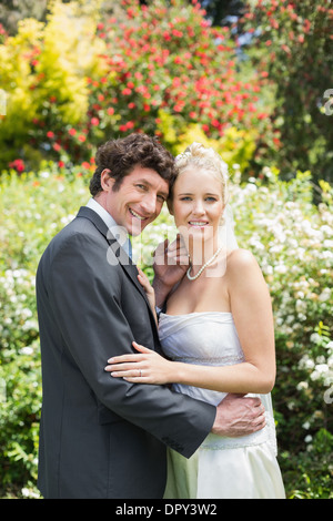 Romantische glücklich Frischvermählten umfassenden Blick in die Kamera Stockfoto