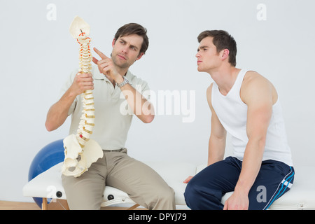 Physiotherapeuten zeigen Patienten etwas auf Skelettmodell Stockfoto