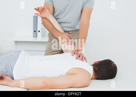 Männliche Physiotherapeut untersucht eine junge mans hand Stockfoto