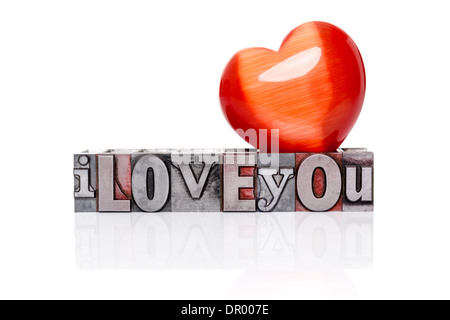 Ich liebe dich in alten gemischte Schriftart Metall-Buchdruck-Blöcke mit einem roten Herz Edelstein an der Spitze, isoliert auf einem weißen Hintergrund. Stockfoto