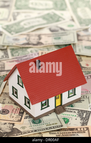 Symbolisches Bild für eine Immobilienfinanzierung mit einem Haus auf Dollarnoten Stockfoto