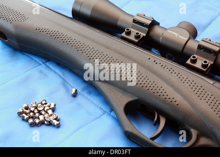 Teil von einem Luftgewehr und Pellets auf blauem Hintergrund Stockfoto