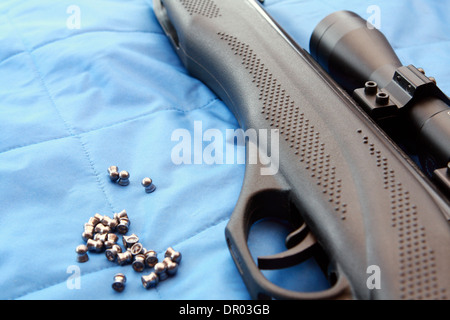 Teil von einem Luftgewehr und Pellets auf blauem Hintergrund Stockfoto