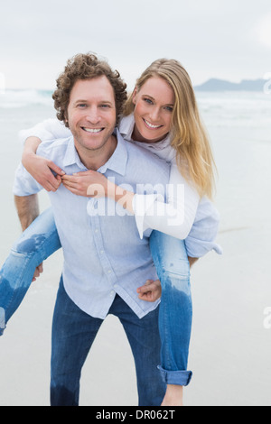 Porträt eines Mannes, die Frau am Strand Huckepack Stockfoto