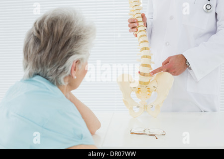 Männlichen Arzt erklären, die Wirbelsäule zu einem älteren Patienten Stockfoto