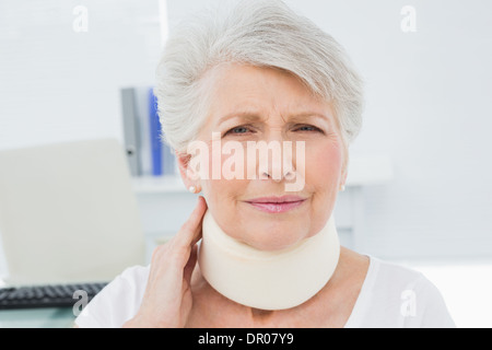 Ältere Frau trägt Halskrause in Arztpraxis Stockfoto
