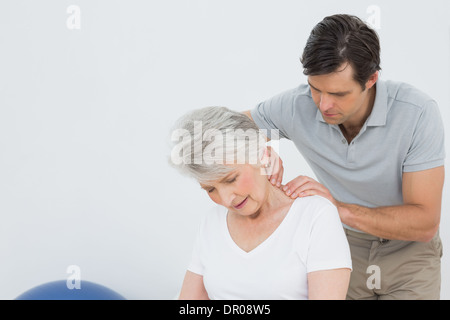 Physiotherapeuten, die eine ältere Frau Nacken massieren Stockfoto