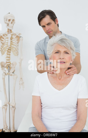 Physiotherapeuten, die eine ältere Frau Nacken massieren Stockfoto