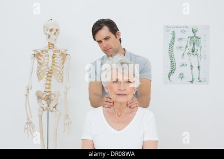 Physiotherapeuten, die eine ältere Frau Nacken massieren Stockfoto