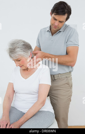 Männliche Physiotherapeuten eine ältere Frau Nacken massieren Stockfoto