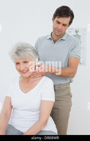 Männliche Physiotherapeuten eine ältere Frau Nacken massieren Stockfoto