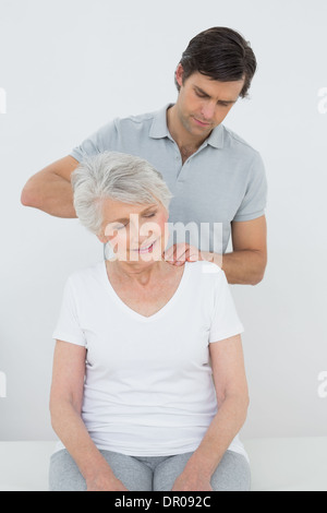 Männliche Physiotherapeuten eine ältere Frau Nacken massieren Stockfoto