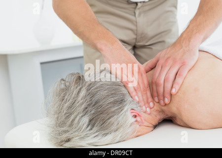 Physiotherapeuten, die eine ältere Frau Nacken massieren Stockfoto