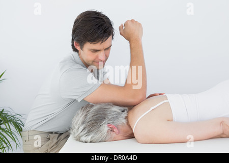 Männliche Physiotherapeuten eine ältere Frau Rücken massieren Stockfoto