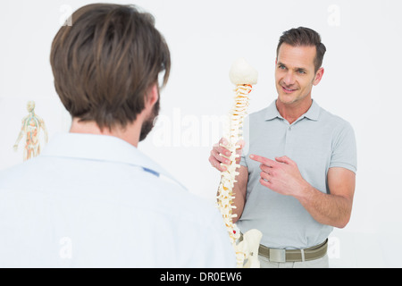 Männlichen Arzt erklären, die Wirbelsäule zu einem Patienten Stockfoto