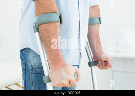 Nahaufnahme eines jungen Mannes mit Krücken Mittelteil Stockfoto