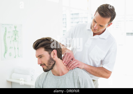 Männlichen Therapeuten massieren Nacken eines jungen Menschen Stockfoto