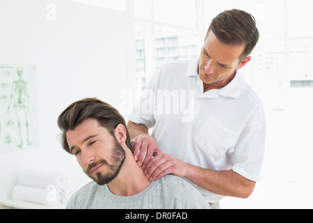 Männlichen Therapeuten massieren Nacken eines jungen Menschen Stockfoto