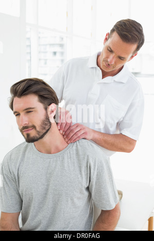 Männlichen Therapeuten massieren Nacken eines jungen Menschen Stockfoto