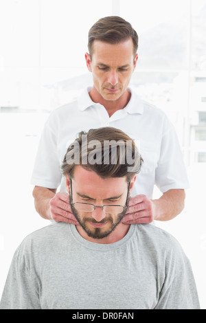 Männlichen Therapeuten massieren Nacken eines jungen Menschen Stockfoto