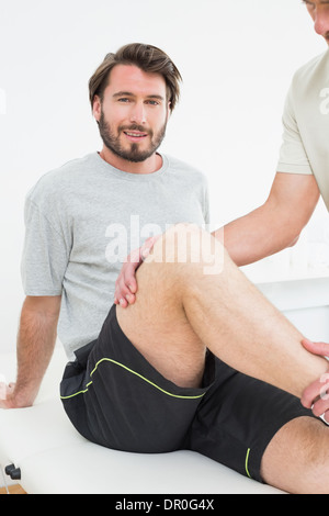 Porträt eines jungen Mannes, der immer seine Knie untersucht Stockfoto