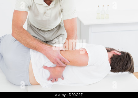 Männliche Physiotherapeut Prüfung des Mannes zurück Stockfoto