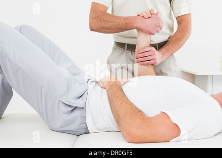 Physiotherapeut untersucht die Hand eines Mannes Stockfoto