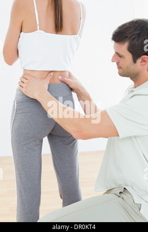 Rückansicht eines Physiotherapeuten untersuchen Rücken Frau Stockfoto