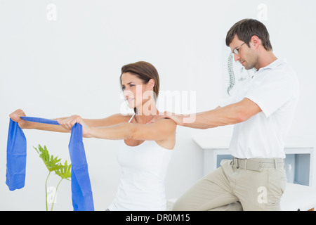 Männlichen Therapeuten unterstützen junge Frau mit Übungen Stockfoto