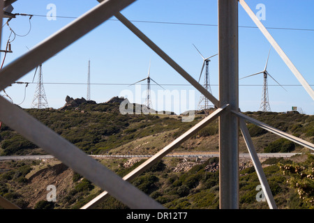 Schauen Sie durch Elektrizität Mast mit Windkraftanlagen Landschaft. Tarifa, Cádiz, Andalusien, Spanien. Stockfoto