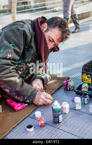 London, UK, 16. Januar 2014. Künstler, Ben Wilson, schafft Kunst Künstler malen auf der Millenium Bridge The English weggeworfenen Kaugummi Flecken auf der Brücke und die Miniatur-Kunstwerke zeichnen Massen von bewundernden Zuschauer. Bildnachweis: Eden Breitz/Alamy Live-Nachrichten Stockfoto