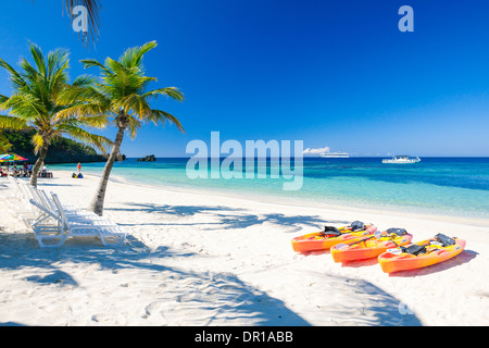 Kajaks am Strand warten Kreuzfahrtschiff im Hintergrund kommt Stockfoto