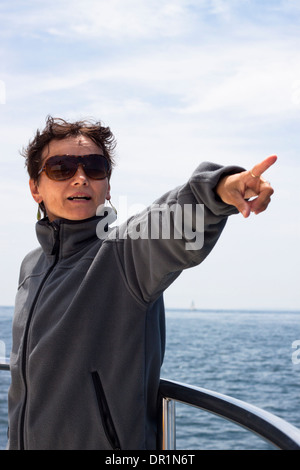 Applying Frau zeigt, mit blauem Himmel und Meer im Hintergrund. Stockfoto
