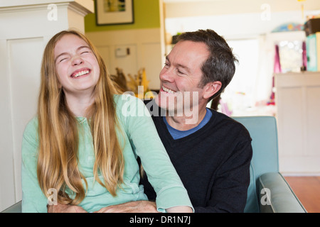 Kaukasische Vater und Tochter lachend im Wohnzimmer Stockfoto