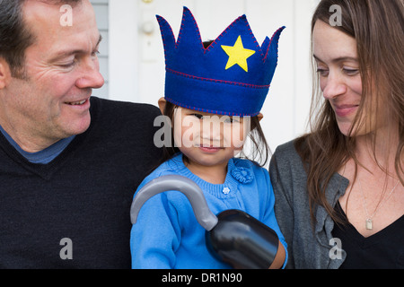 Eltern, die Tochter mit Haken und Krone hielt Stockfoto